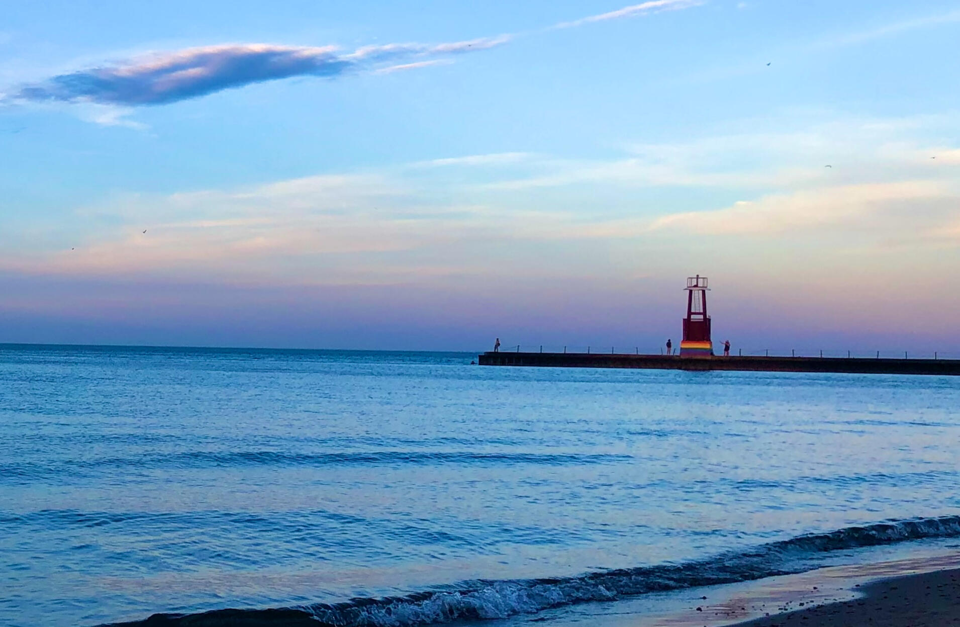Photo by Cynthia Weiss - Osterman Beach A photo of Lake Michigan looking toward a sky at Osterman Beach. The lake is very blue and the sky is capturing the pretty colors of the sunrise.